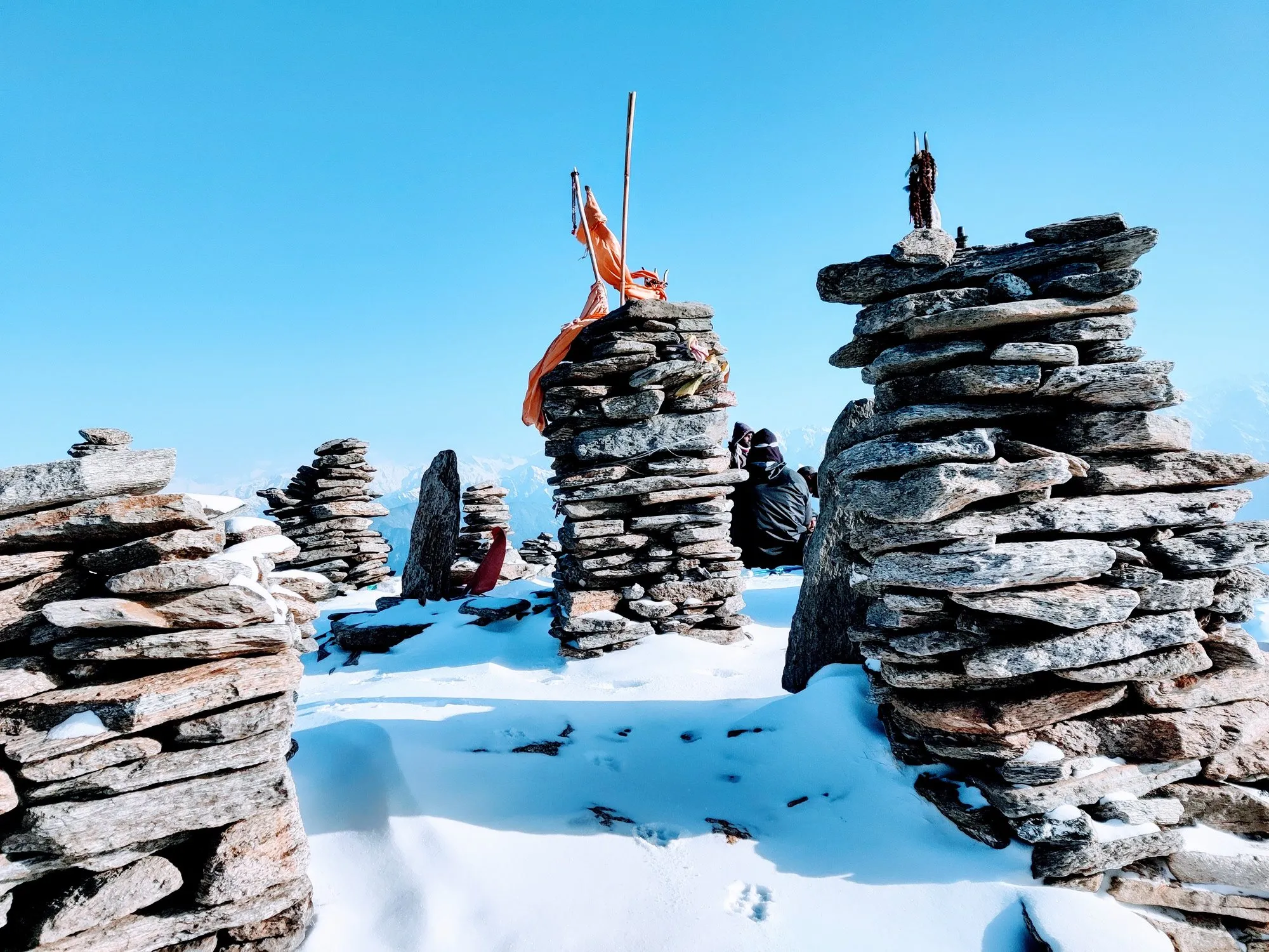 Kedarkantha summit — stone cairns and prayer flags